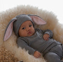 Baby wearing a gray bunny costume with long lop ears and a fluffy tail