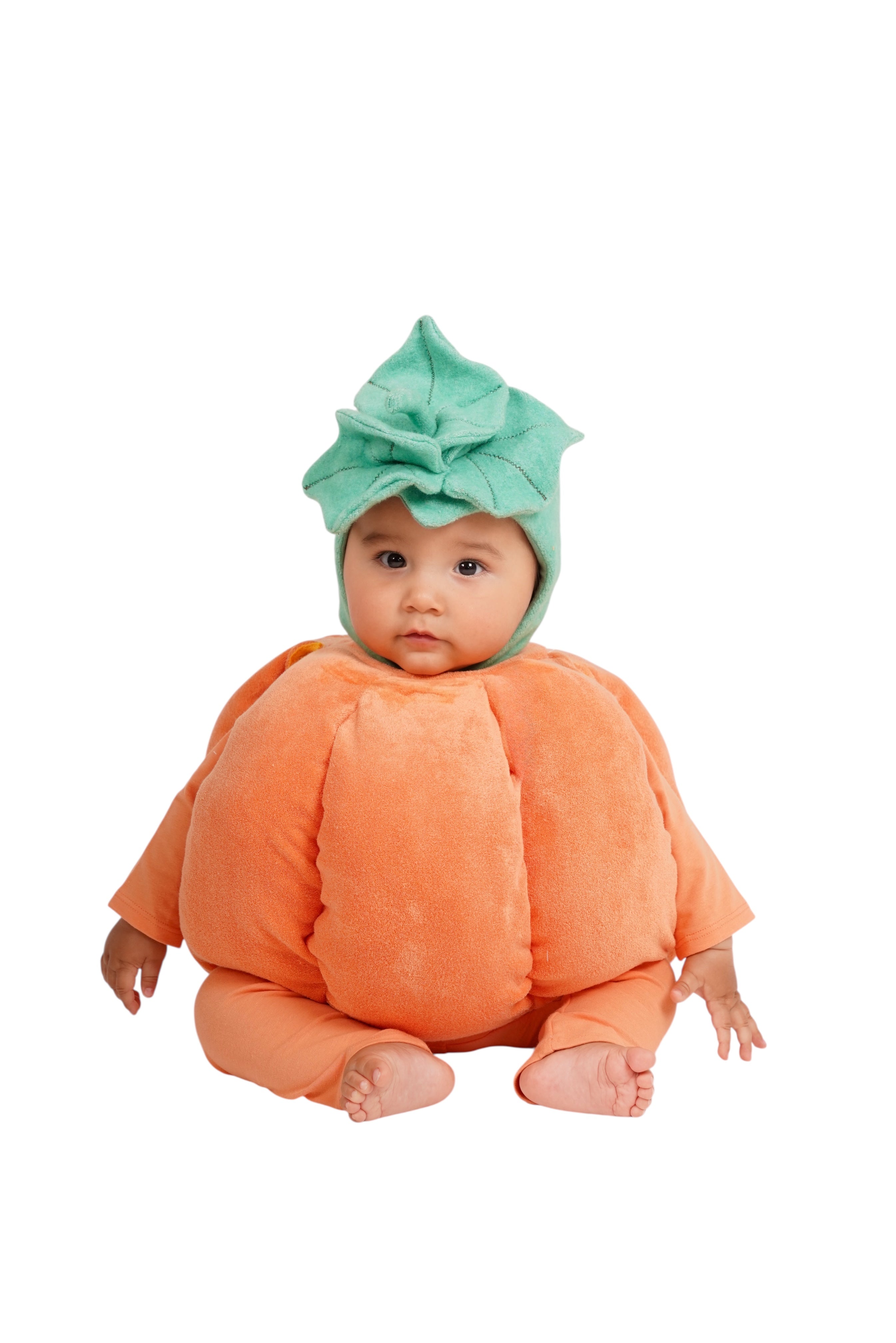 Infant wearing a soft orange pumpkin Halloween costume on a white background
