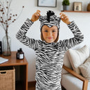 Child wearing a black-and-white zebra costume with ears, mane and striped tail