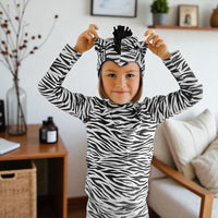 Child wearing a black-and-white zebra costume with ears, mane and striped tail